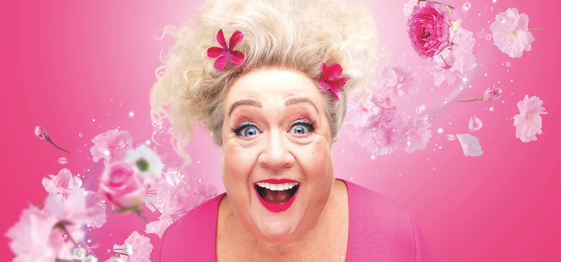 Christel de Laat in roze, met bloemen om haar heen