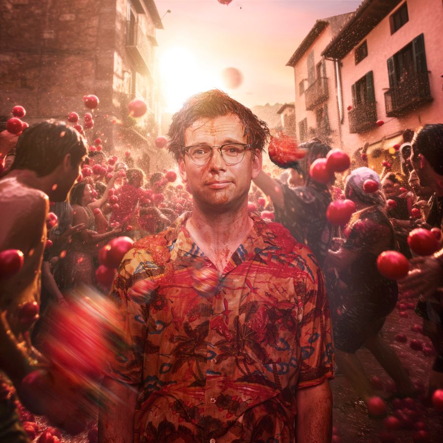 Pieter Derks staat te midden van een drukke straat. Er vliegen tomaten door de straten.