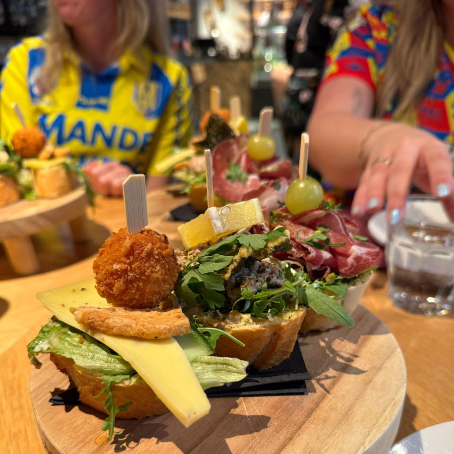 Belegde broodjes met prikkers op een ronde houten plank