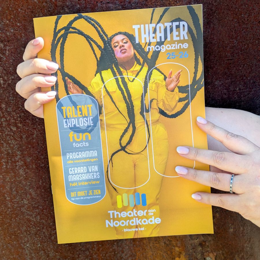 Twee handen houden het nieuwe theatermagazine van de Blauwe Kei vast. Op de cover staat Isabella Kafando