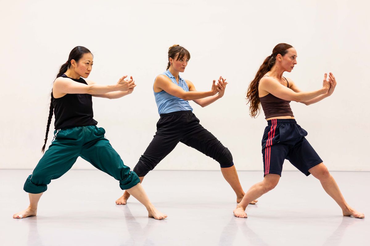 drie dansers met armen schuin naar voren gebogen