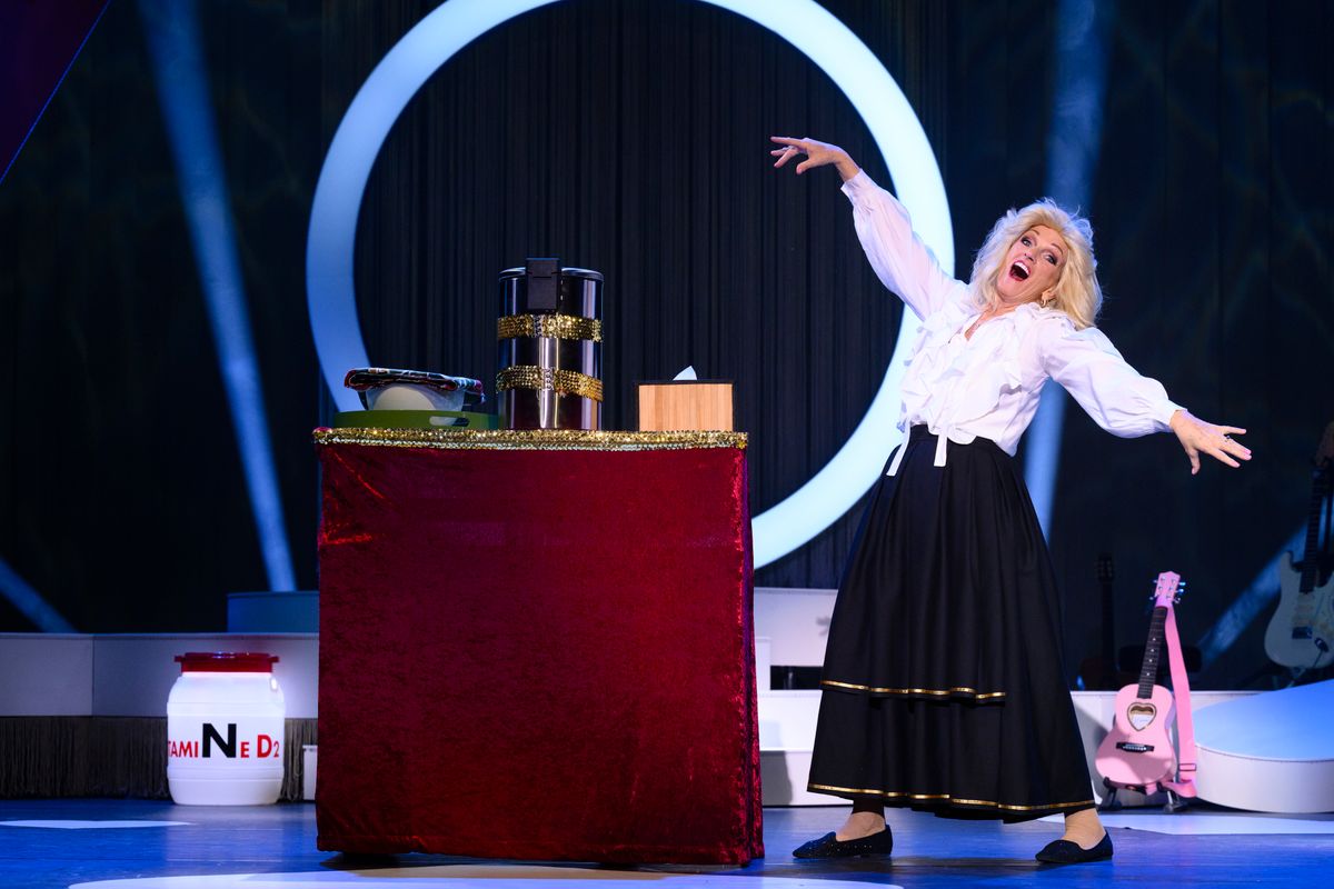 Tineke in zwarte rok en witte blouse en een desk