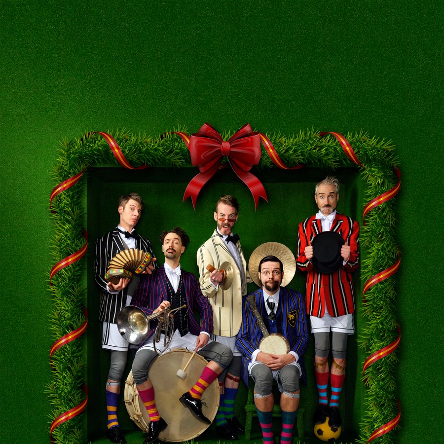 De vijf mannen van Släpstick staan in pakken omkaderd in een lijst van dennentakken met een rode strik, helemaal in kerststijl