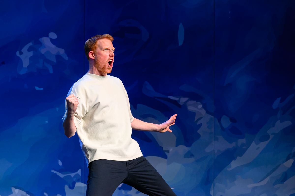 Rene van Meurs staat in een schreeuwende houding voor een blauwe achtergrond