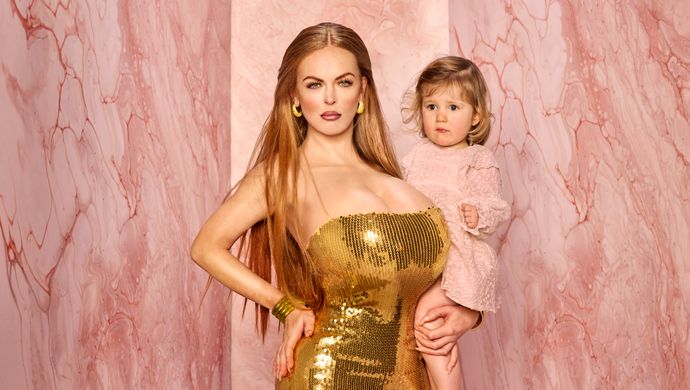 Lisa Ostermann in gouden jurk ze heeft het handje van een meisje vast