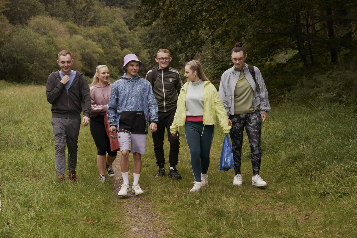 Groep jongeren lopend in een weiland