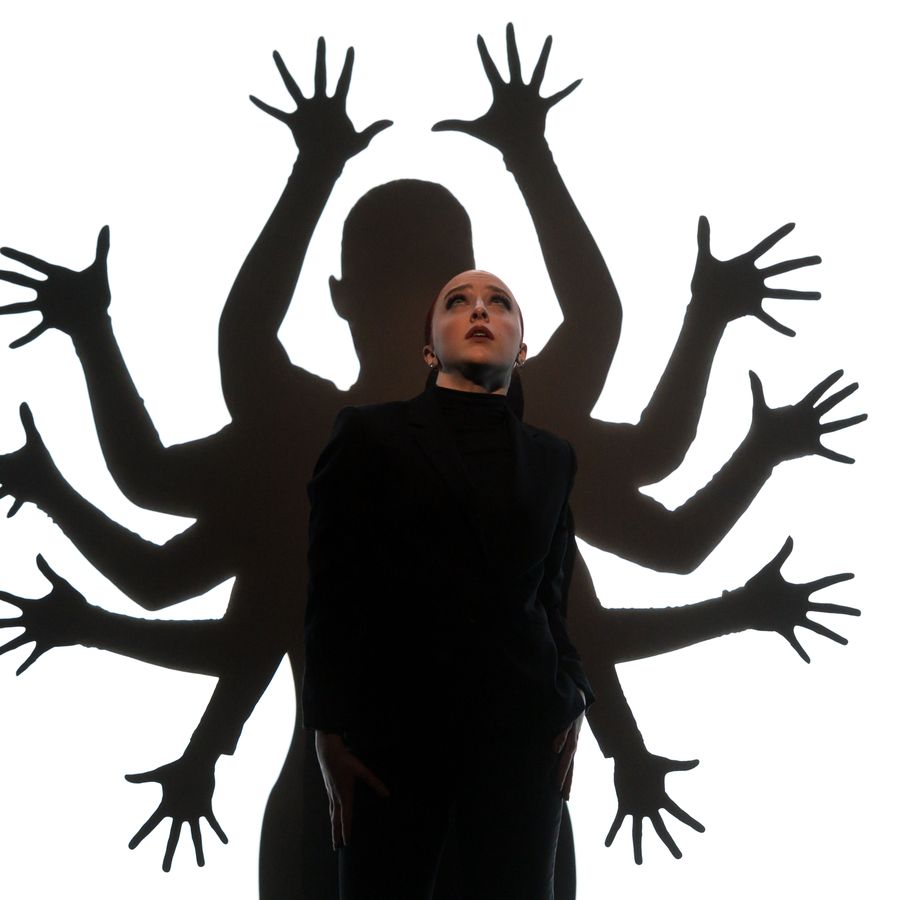 Dansers voor wit scherm, handen vormen een silhouette