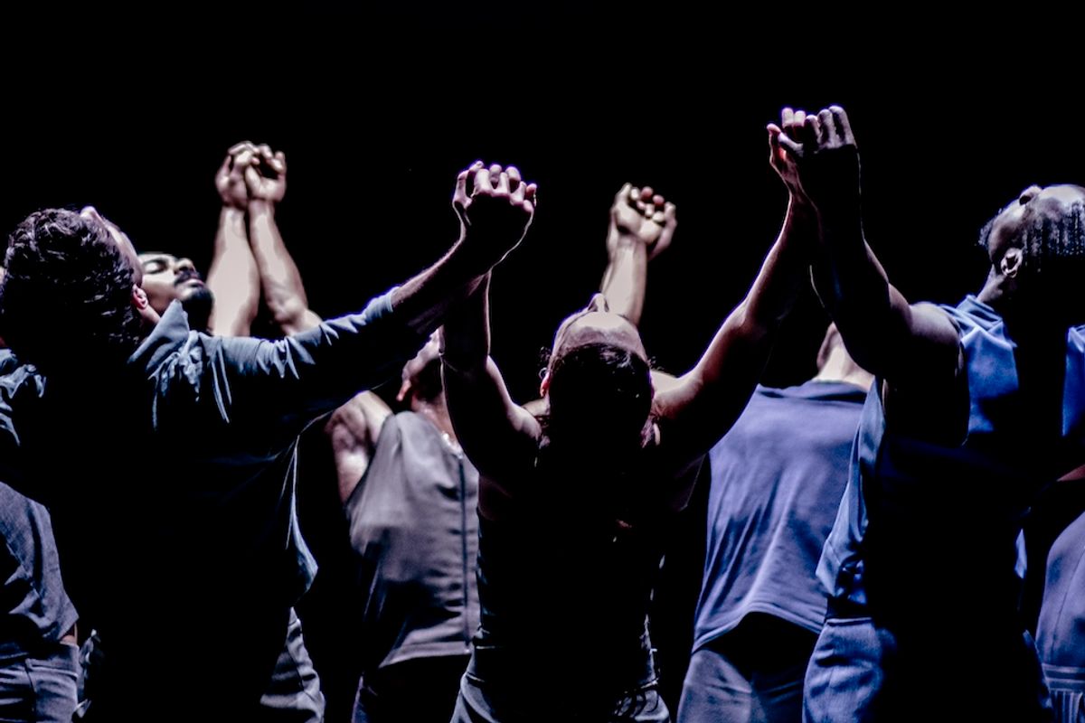 groep dansers in cirkel met armen en zicht omhoog