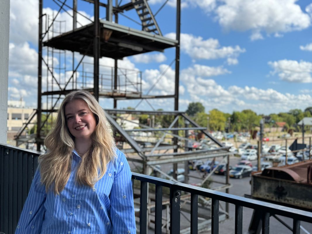 Demi op balkon, op achtergrond parkeerplaats Noordkade