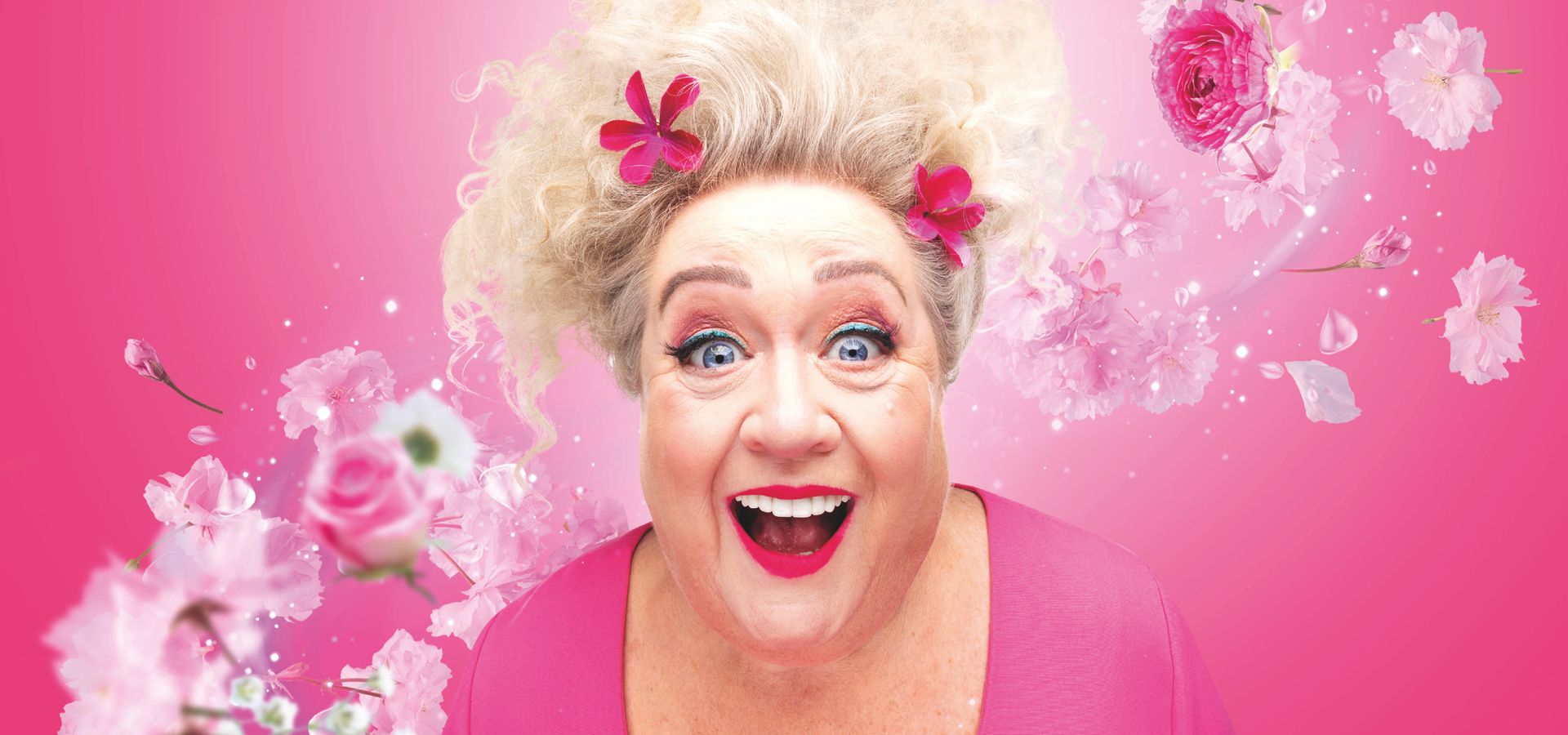 Christel de Laat in roze, met bloemen om haar heen