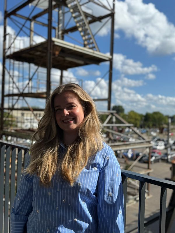 Demi op balkon, op achtergrond parkeerplaats Noordkade