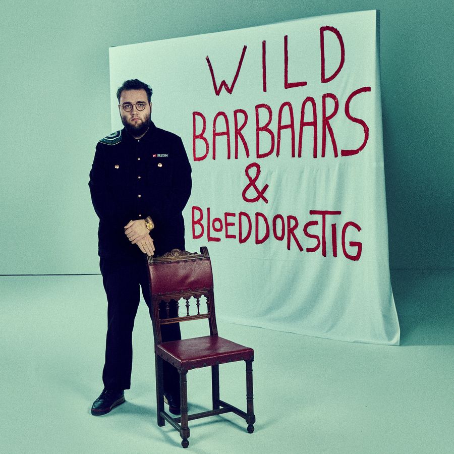 Sezgin Güleç  voor een spandoek met de tekst Wild Barbaars & Bloeddorstig