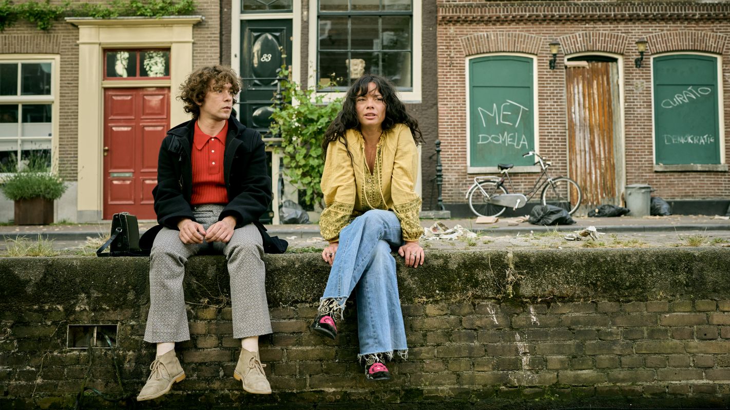 twee mensen zittend aan kade gracht