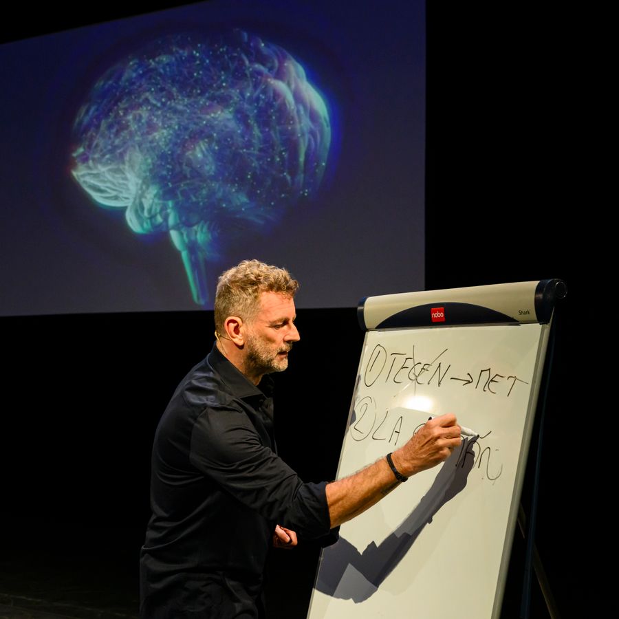 Kluun schrijft iets op een flipover