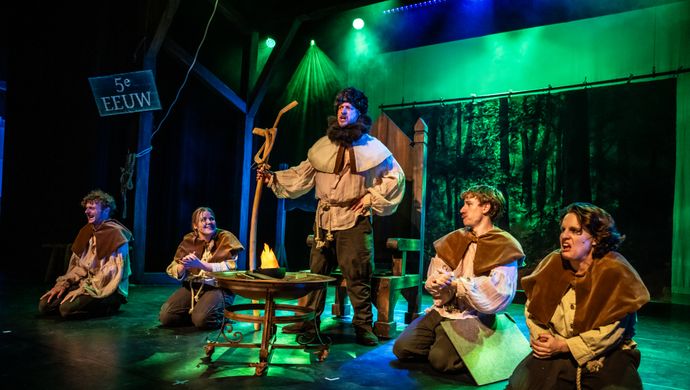 vijf castleden in middeleeuwse kleding op het podium