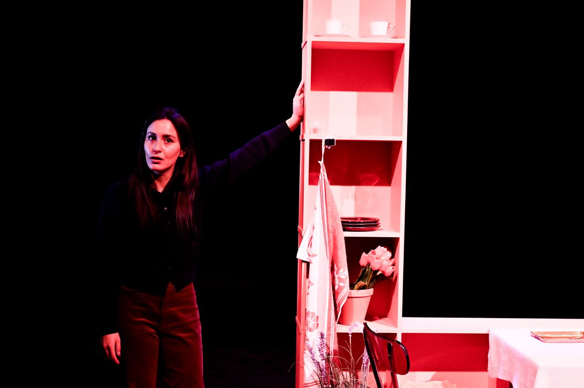 Dilan Yurdakul naast een schappenkast op podium