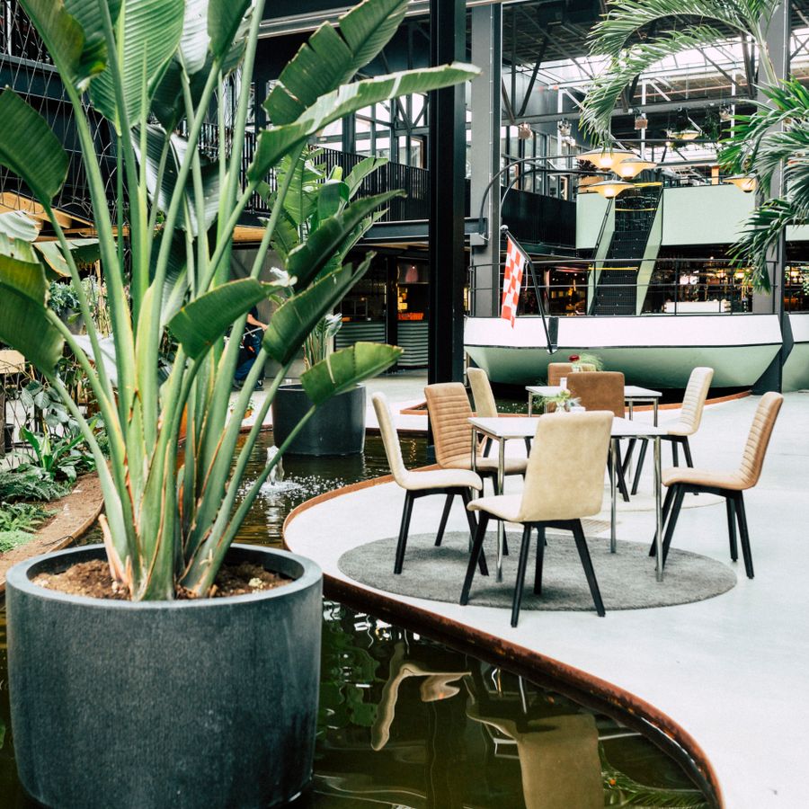 Foyer Blauwe Kei, water met planten en tafel met 4 stoelen