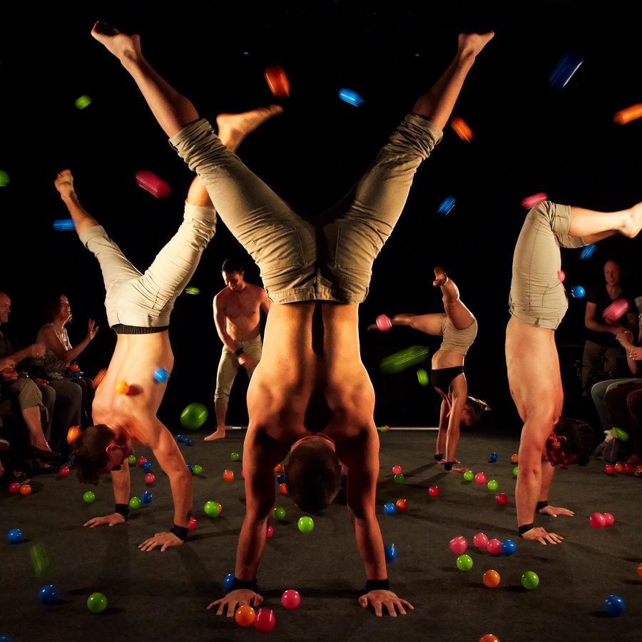 Drie acrobaten doen een handstand